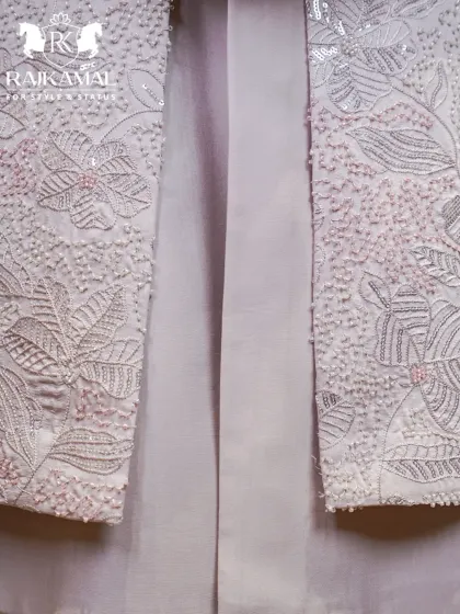 A detailed shot of the delicate floral embroidery on the white Indo-Western jacket, showing the fine craftsmanship.