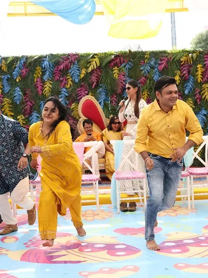 The family running on stage for a game. The colorful, quirky decor of this Haldi set the perfect tone for a fun filled day.
