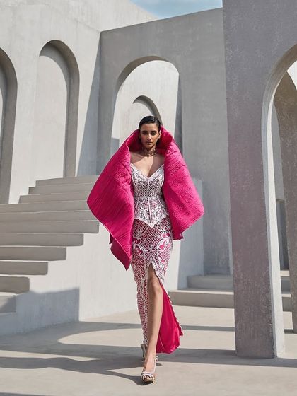 A fully embellished corset and slit skirt in a dreamy pink hue, detailed with delicate pearls and finished with a quilted coverup for a touch of luxe.