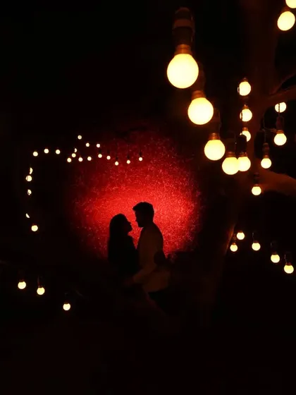Under a canopy of lights, we found a moment of pure magic. Silhouette photography is one of my favorite ways to create a dramatic and romantic mood. It focuses entirely on your connection, outlined against the warm glow of the evening.