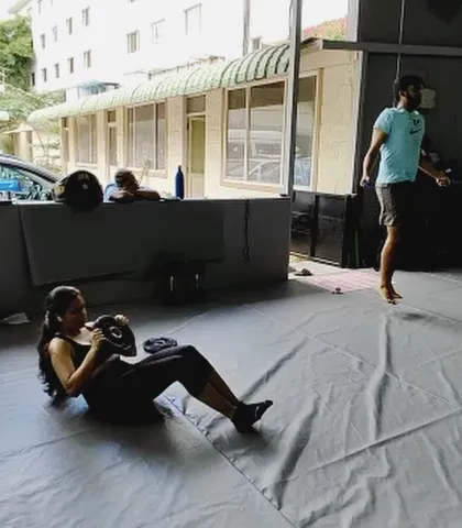 A typical scene at The Works: one member doing sit ups with a weight plate while another skips rope in the background.