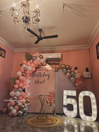 The full view of the lovely 50th birthday setup, complete with a crystal chandelier adding to the room's elegance.