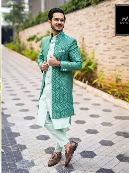 A showcase of modern elegance with a traditional touch. This client is wearing a custom sea-green Lucknowi jacket with a geometric pattern, paired with a light kurta for a fresh, sophisticated look ideal for daytime events or receptions.