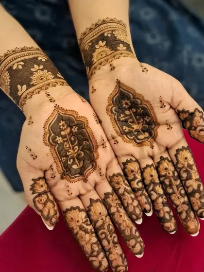 An elegant and modern henna design perfect for a wedding guest or festive occasion. This style features delicate floral work on the fingers and a beautiful architectural motif on the palm, leaving negative space for a contemporary feel.
