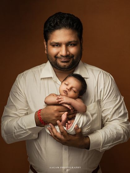 In your arms, a tiny miracle. A proud father holds his sleeping newborn, a classic portrait that every dad will cherish.
