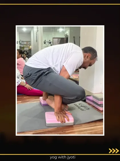 A student holds Bhujapidasana on blocks, demonstrating great arm and core strength.