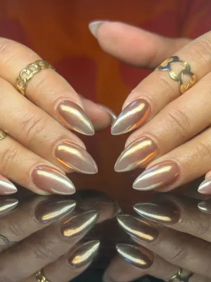 A stunning rose gold chrome finish on almond-shaped nails, offering a trendy and sophisticated metallic look.