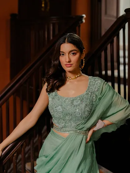 A closer look at the beautifully embroidered blouse of the sage green draped saree.
