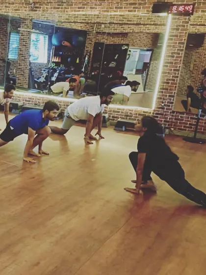 I guide my students through every movement. Here, we are in a deep low lunge, building strength and flexibility in a focused group setting.