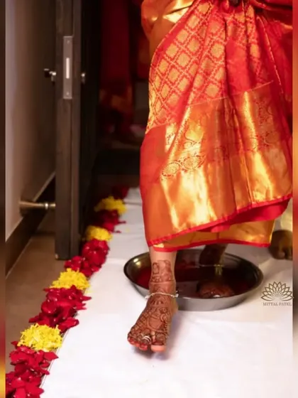 A beautiful, candid shot capturing the bride's foot with its intricate mehndi during a wedding ritual. This shows how the foot mehndi is an essential part of the complete bridal look.