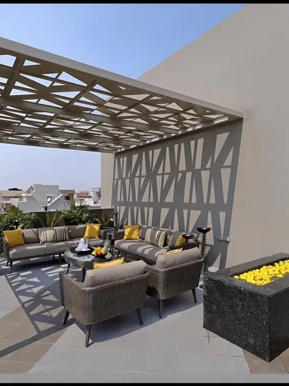 This modern terrace features a custom CNC-cut pergola that casts dynamic patterns of light and shadow. Paired with a matching privacy screen, it transforms the rooftop into a sophisticated and comfortable outdoor lounge, perfect for relaxation or entertaining.