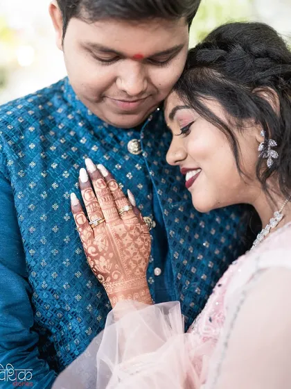 Details matter. This close-up shot focuses on the bride's intricately designed mehndi and her gentle embrace, telling a story of love and tradition. It’s a quiet, tender moment that speaks volumes.