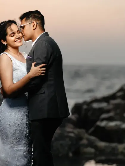 A tender kiss on the cheek against a soft sunset sky. This post-wedding portrait on the rocks is all about capturing a quiet, romantic moment in a beautiful, natural setting.