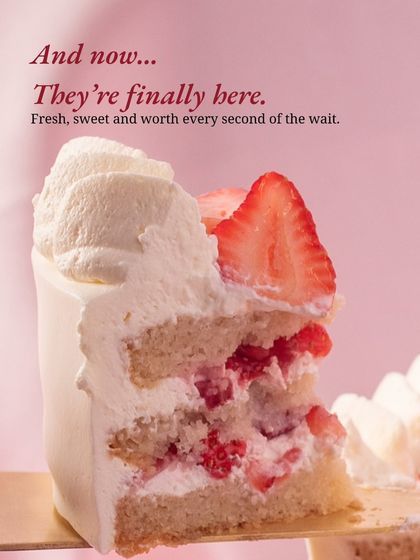 A teaser shot announcing the return of strawberry season. A perfect slice of fresh cream and strawberry cake, signifying that the wait for fresh, sweet berries is over.