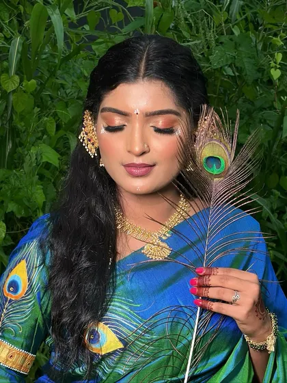 A serene portrait with eyes closed, showcasing the beautiful eye makeup and the artistic details of the Radha-inspired look.