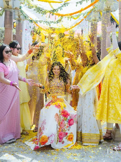 The bride's friends and family shower her with a storm of marigold petals, creating a picture of pure joy.
