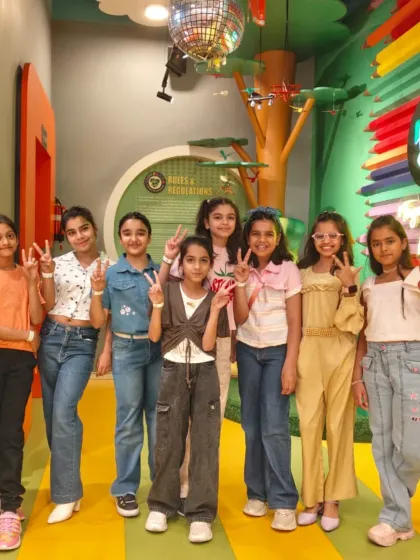 A group of friends flashes peace signs, capturing the fun and positive vibe of a day spent at Tingaland.