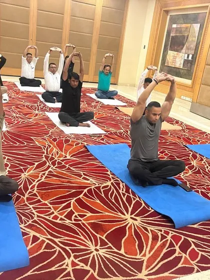 A seated stretching exercise during the corporate session. We focus on relieving tension in the neck, shoulders, and back, which are common issues for those with desk jobs.