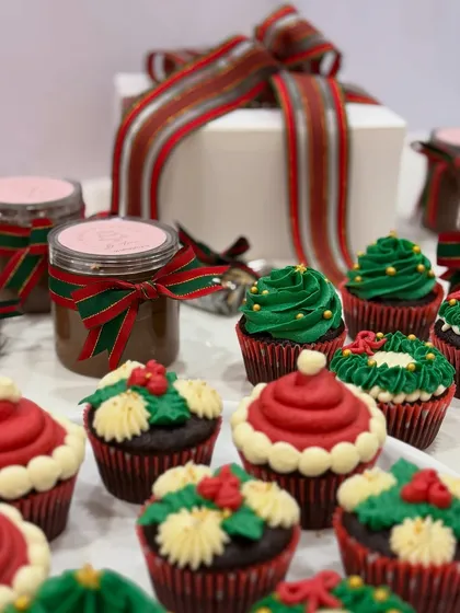 A festive spread of my Christmas cupcakes and other holiday treats. The red and green buttercream and festive ribbons make for a beautiful holiday display.