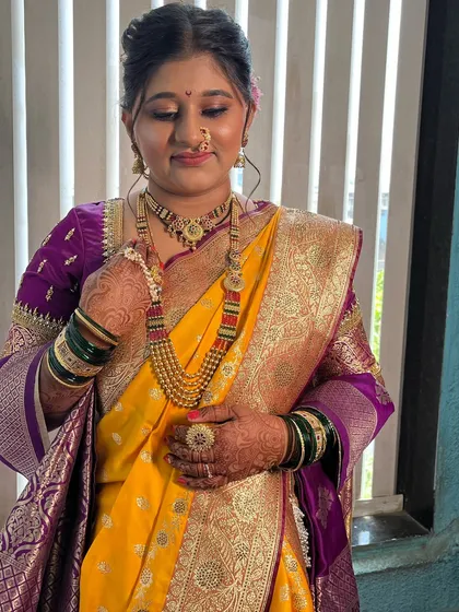 Admiring the details. The makeup is paired with traditional jewellery, including the distinctive Maharashtrian nath and layered necklaces.