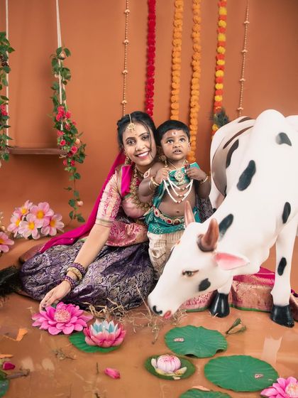 This little Krishna and his mom are posing with our life-sized cow prop, part of our grand Janmashtami setup. These sessions are filled with playful and traditional elements.