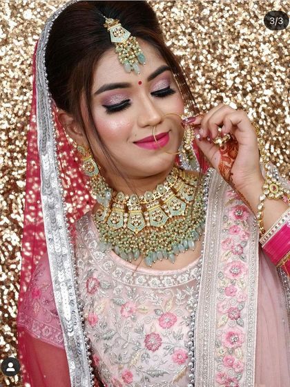 A close-up of the mint-green Kundan jewellery against the pink floral lehenga. This color combination is perfect for daytime weddings or pastel-themed events.