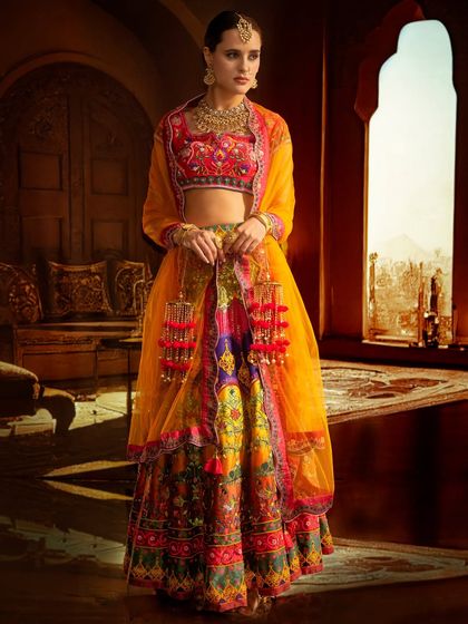 This colorful ethnic wear is set against a projected heritage interior. The lighting is balanced to bring out the vibrancy of both the outfit and the intricate background.