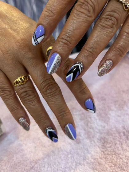 A modern geometric design with a mix of lavender, black, white, and silver glitter polish.