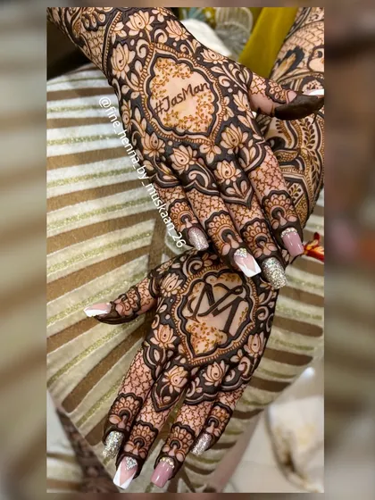 A bold and beautiful design for the back of the hands. I love creating these statement pieces with personalized initials, like the 'JasMan' and 'M' monograms, framed by intricate floral work.