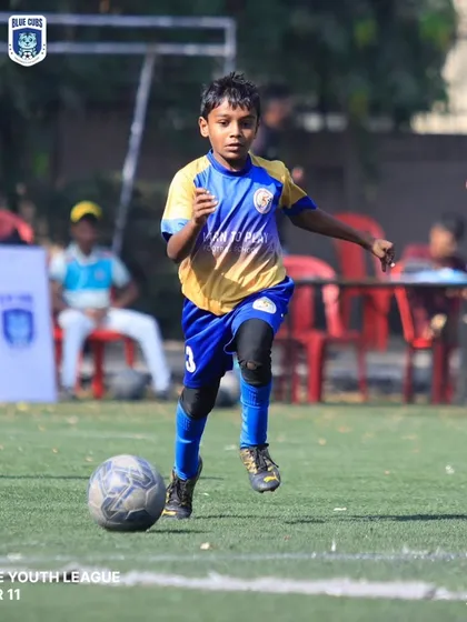 A young player from our U11 team running with the ball, showing speed and control.