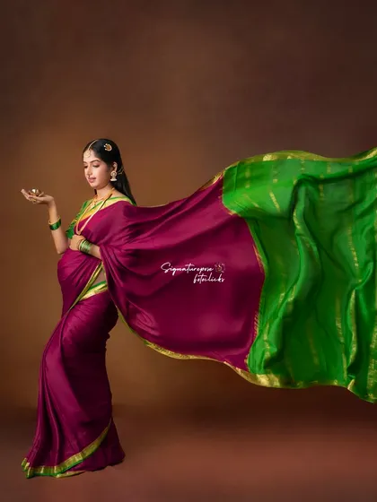 The flowing saree creates a sense of movement and grace in this beautifully composed traditional maternity portrait.