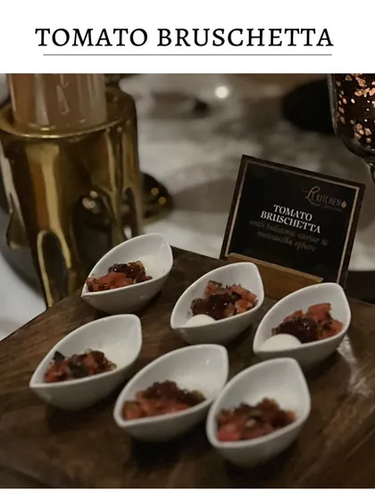 Classic tomato bruschetta served in individual, modern ceramic spoons. The fresh tomato and basil topping sits on a small piece of mozzarella for a creamy finish.