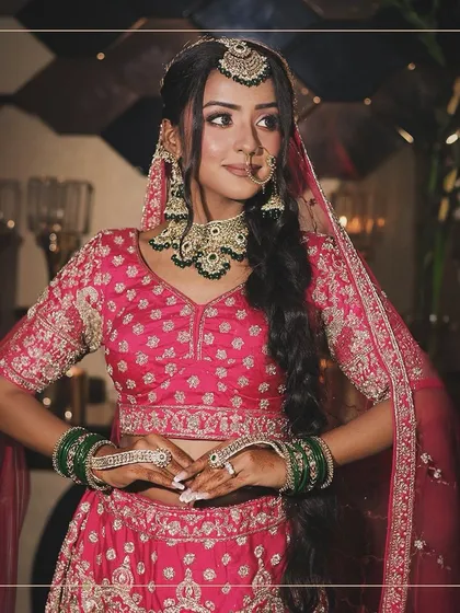 The perfect pose to show off your complete bridal look. The pink lehenga, green bangles, and traditional jewellery come together for a classic wedding style.