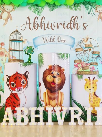 A close-up of a jungle-themed backdrop, featuring cute cartoon animals and a 'Wild One' banner.