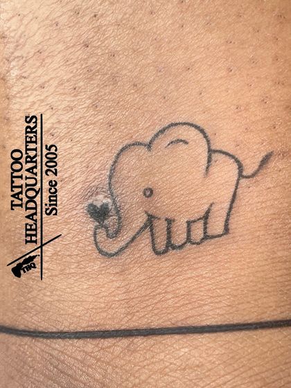A very simple outline of a baby elephant holding a heart in its trunk, a cute and minimalist design.