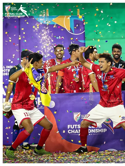 Celebrating on the podium with the team flag, a moment of pride and joy.