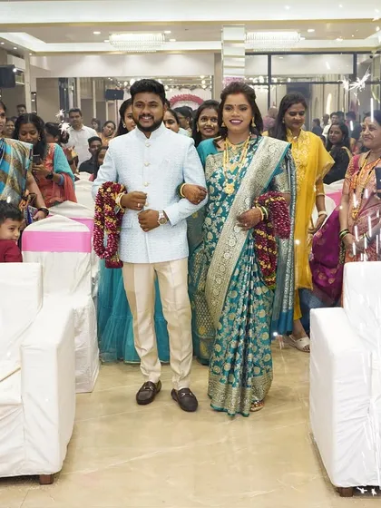 Making a grand entrance at their reception. The bride looks stunning in her teal saree with makeup that enhances her natural glow.