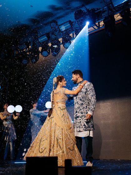 The couple shares a dance under a magical spotlight, a moment of pure romance. We use professional lighting and effects to create these cinematic memories.