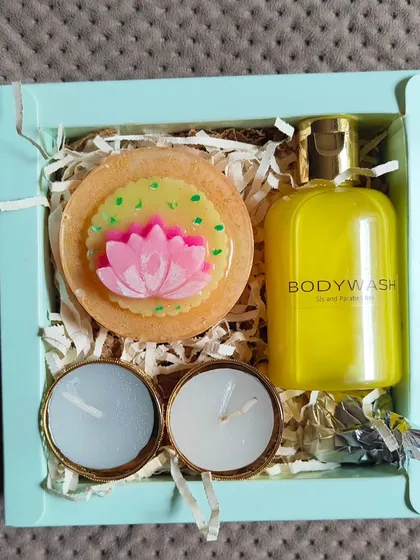 A simple and elegant Diwali gift set, including a lotus-themed soap, body wash, and two small tea-light candles.