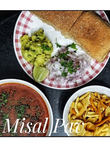 A plate of authentic Misal Pav, served deconstructed with the spicy sprout curry (usal), farsan, chopped onions, and pav.