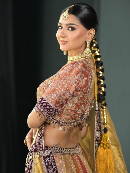This look is all about traditional elegance. The intricate braid, known as a parandi, and the soft, minimal makeup create a chic and classic look for this bride.