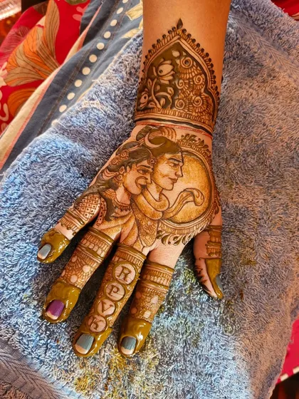 For festive occasions like Teej or Karwa Chauth, a mythological design is perfect. Here is a portrait of Shiva and Parvati, created with delicate lines and shading to capture their divine essence. I also included the couple's initials on the fingers for a personal touch.