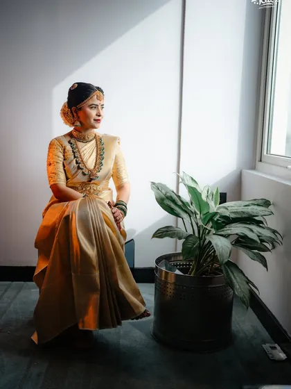 Dressed in a stunning gold saree, this bride is a picture of timeless elegance. Her makeup features a classic red lip and defined eyes, a look that is both bold and traditionally beautiful.