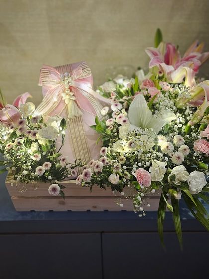 A single gift box, wrapped to perfection and nestled in a crate overflowing with fresh flowers and fairy lights. This is how I turn a simple gift into a breathtaking floral presentation for a wedding trousseau.