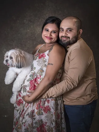 This pose beautifully integrates the family's pet into the maternity portrait. The expecting mother holds their dog close to her baby bump, symbolizing the bond between her two babies.