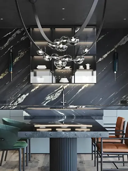 For this project, we created a statement kitchen that doubles as a luxurious entertainment space. The design is defined by a dramatic floor-to-ceiling black marble wall, a custom island with an integrated dining table, and a unique sculptural light fixture. This is a perfect example of our bespoke kitchen interior services for high-end homes in Bangalore.