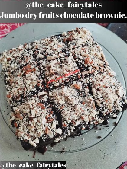 A top-down view of the jumbo dry fruits chocolate brownie, cut into nine generous squares. You can see the rich chocolate base beneath the crunchy nut topping.