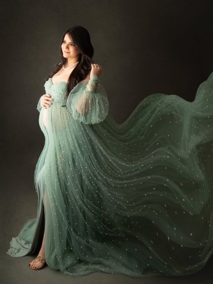 The tossed fabric of this sheer green gown creates a beautiful, wing-like effect in this dynamic maternity portrait.