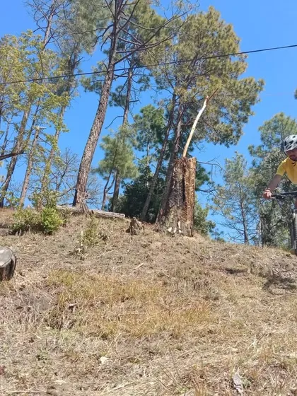 An action shot from one of our workshop sessions. Here, a rider applies learned techniques for handling and body position on a downhill section of the trail, a key skill for any mountain biker.