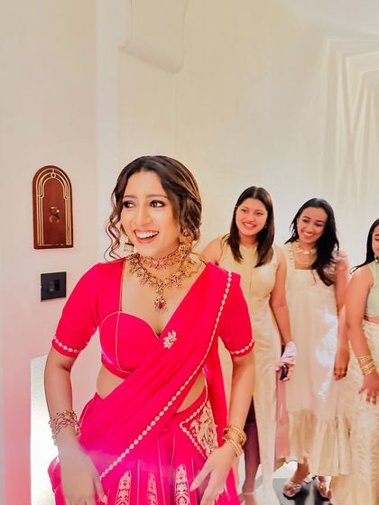 The bride-to-be's joy is infectious! A beautiful moment from an engagement party, where she is perfectly draped in a pink lehenga saree.